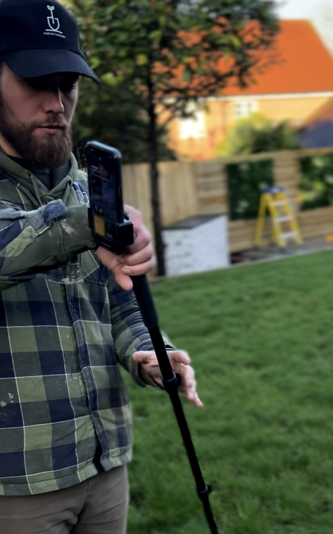 Fresh Air Landscapes surveyor capturing precise site measurements and levels in a client's garden