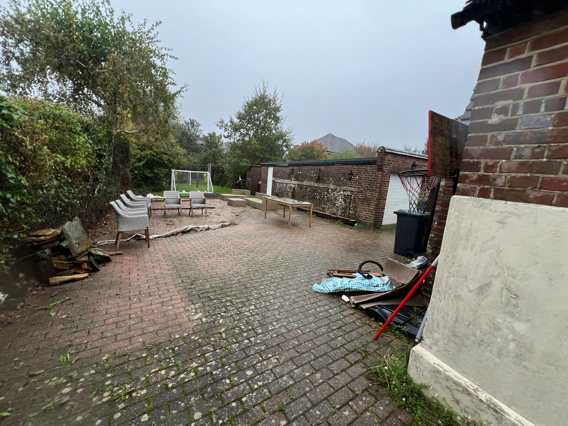 Original garden - wide view of tired block paving, mixed seating and unloved boundary walls