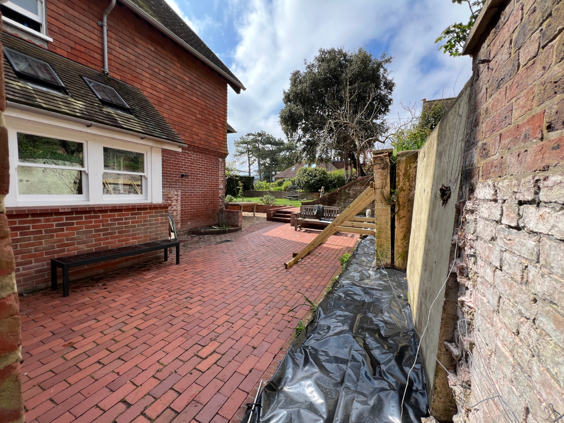 Original courtyard - narrow side passage with exposed brick wall and black sheeting