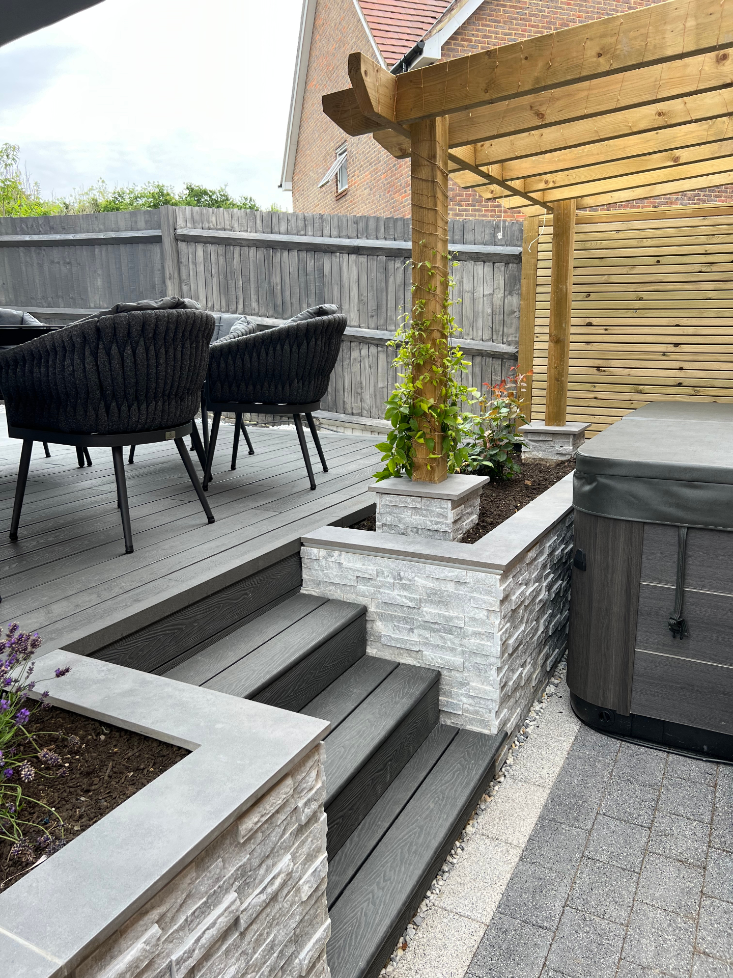 Finished garden - composite steps, crisp stone copings and pergola posts beside the spa terrace