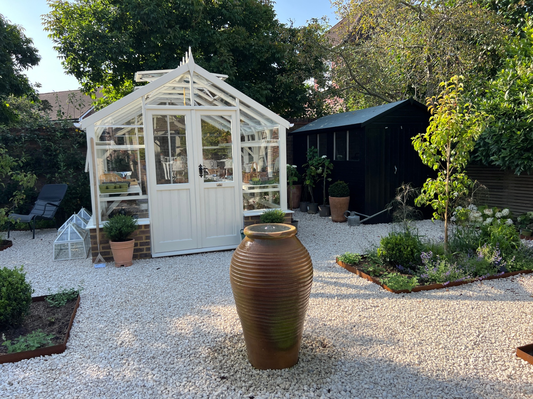 Walled flower garden - glasshouse, urn and cold frame in golden afternoon light